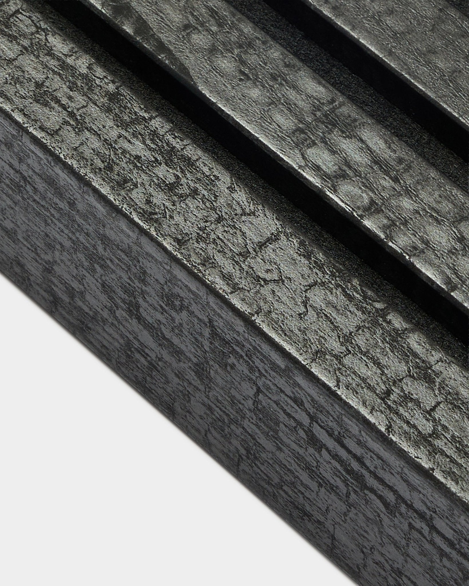 Close-up of WoodUpp Akupanel end lamella in Charcoal, 6.7 cm wide, featuring parallel acoustic slats and distinctive wood grain texture.
